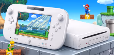 White Wii U console and GamePad displaying a level against a vibrant Super Mario themed background.